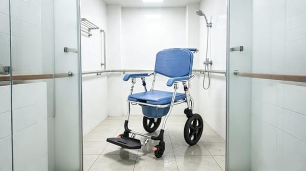 Shower Wheelchair Supplier: Procurement & Safety Guide for Hospitals & Distributors 3 Aluminum shower commode wheelchair in hospital bathroom clinical setting with wet tile floor
